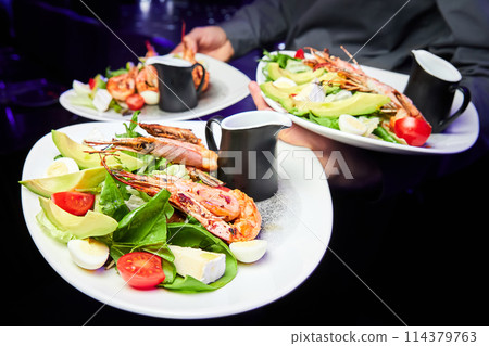 Salad with avocado, tiger prawns, tomatoes and quail eggs 114379763