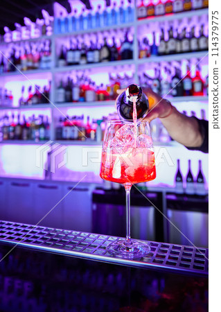 Bartender prepares alcoholic cocktail on bar counter 114379775