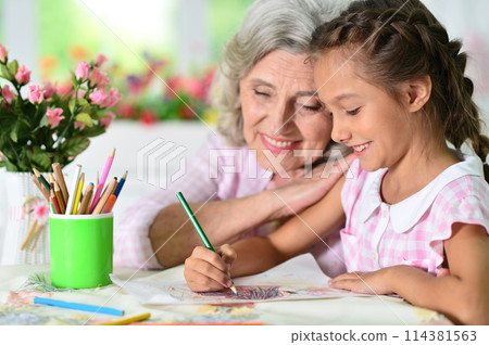 Portrait of a cute little girl drawing with her grandmother Portrait of a cute little girl drawing with her grandmother 114381563