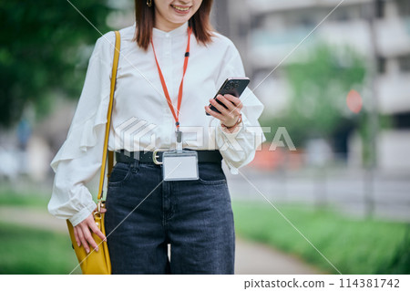一個操作智能手機的年輕女子 114381742