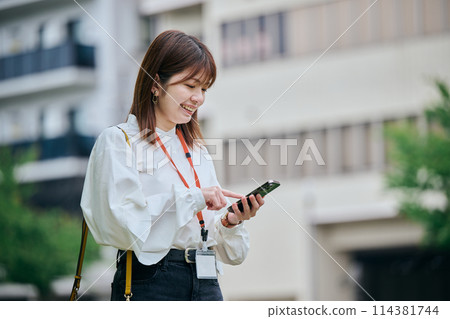 A young woman operating a smartphone 114381744