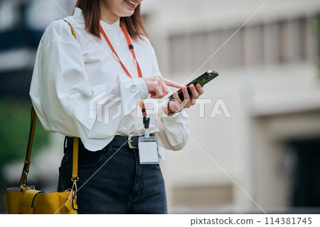 A young woman operating a smartphone 114381745