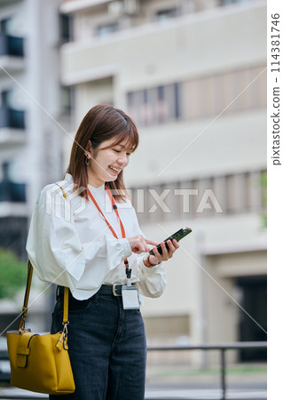 A young woman operating a smartphone 114381746