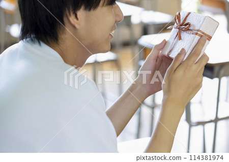 High school boy receiving a gift 114381974