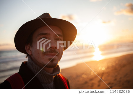 Contemplative walk man enjoys sunset by the sea. 114382086