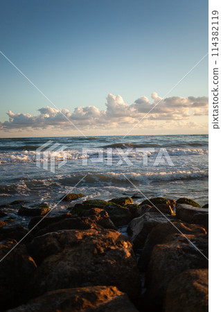 Golden hour transforms beach into serene evening vista. 114382119