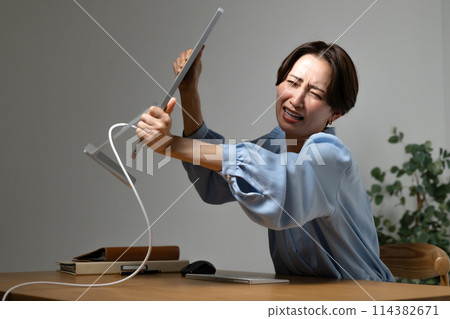 Woman tired from working on a computer 114382671