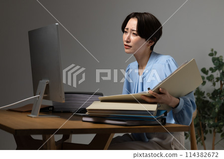 Woman tired from working on a computer 114382672