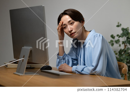 Woman tired from working on a computer Woman tired from working on a computer 114382704