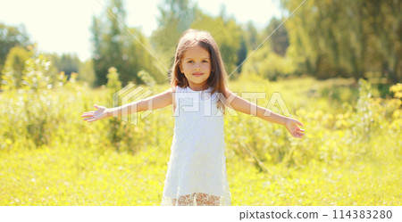 Happy little girl child walking in sunny summer park 114383280