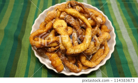 A tray of fried dough snakes with sugar ready to eat. Italian tradition. A tray of fried dough snakes with sugar ready to eat. Italian tradition. 114383673