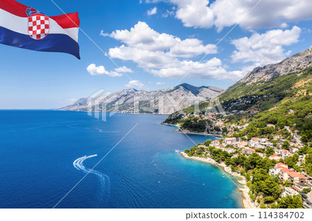 Croatian flag against coastline with Brela town and Adriatic sea in Makarska riviera, Dalmatia, Croatia Croatian flag against coastline with Brela town and Adriatic sea in Makarska riviera, Dalmatia, Croatia 114384702