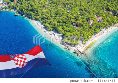 Punta Rata beach with Croatien flag against Adriatic clean sea water and white sand on the beach in Croatia 114384711
