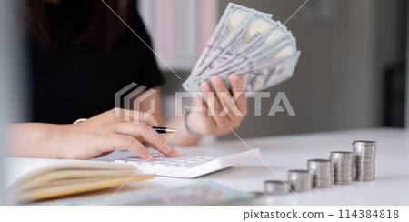 Women is keeping a record of his income and expense, he plans his finance by using his monthly savings to buy funds to make it grow faster. Concept of saving money for investment 114384818