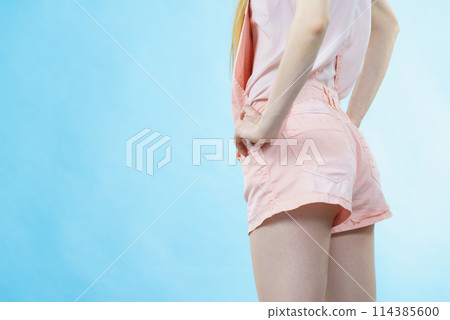 Woman in dungarees back view 114385600