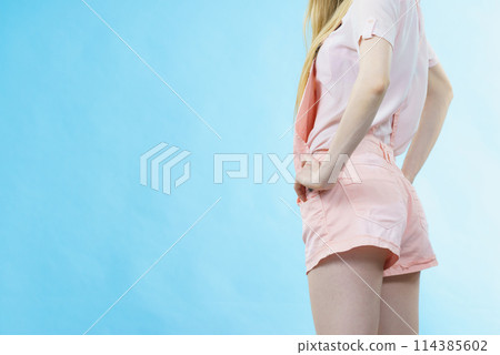 Woman in dungarees back view Woman in dungarees back view 114385602