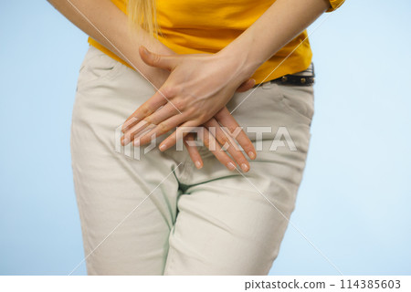 Woman with hands holding her crotch 114385603