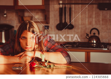 Worried man with rose and mobile phone. 114385668