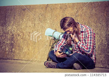 Man tourist backpacker sitting with tablet outdoor Man tourist backpacker sitting with tablet outdoor 114385713