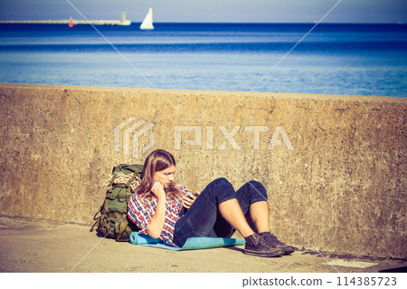 Man tourist backpacker sitting with tablet outdoor 114385723