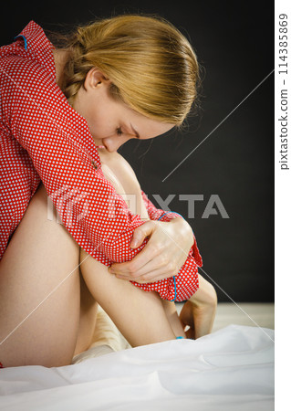 Sad depressed young woman in bed 114385869