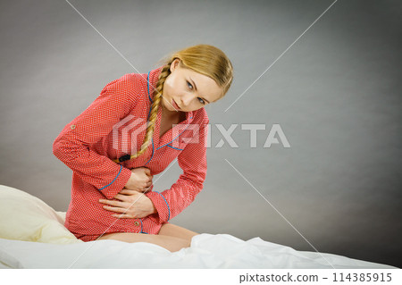 Sad young teenager woman on bed feeling pain Sad young teenager woman on bed feeling pain 114385915