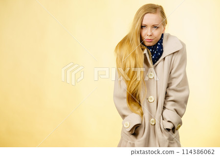 Woman wearing autumnal beige coat Woman wearing autumnal beige coat 114386062