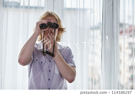 Man with binoculars spying on neighbors 114386297
