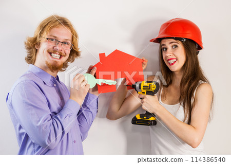 Man and woman holding house and drill 114386540