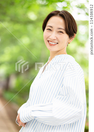 A woman walking in the fresh green A woman walking in the fresh green 114386912