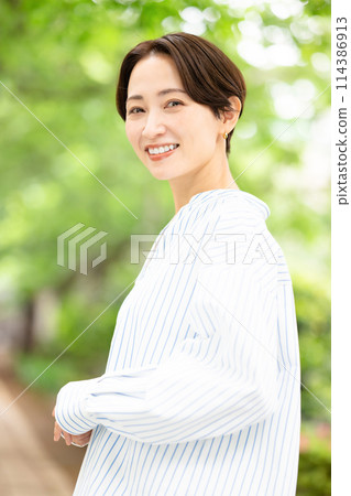 A woman walking in the fresh green A woman walking in the fresh green 114386913