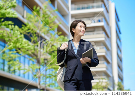 Businesswoman walking in the city 114386941