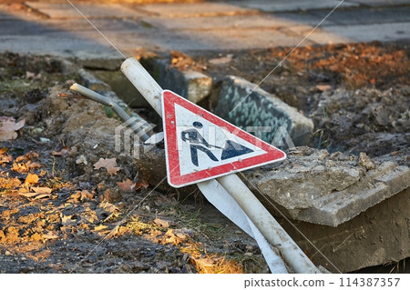 Construction site sign over a utility hole Construction site sign over a utility hole 114387357