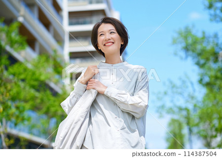 一個女人提著購物袋走在街上 114387504