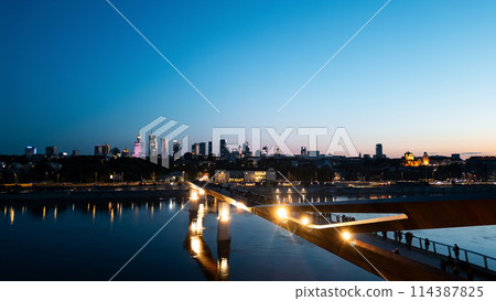 newly built pedestrian and bicycle modern bridge over Vistula river at night, illuminated contemporary architecture of Warsaw, aerial top view newly built pedestrian and bicycle modern bridge over Vistula river at night, illuminated contemporary architecture of Warsaw, aerial top view 114387825