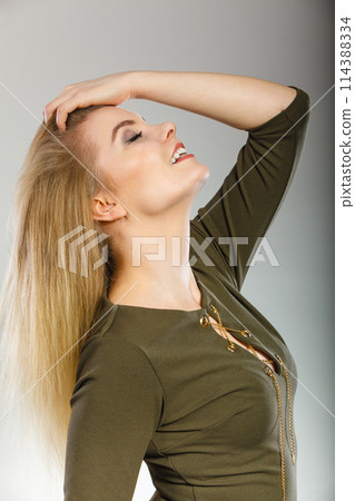 Attractive blonde woman wearing tight green khaki top 114388334