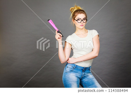 Woman holding big oversized pencil thinking about something Woman holding big oversized pencil thinking about something 114388494