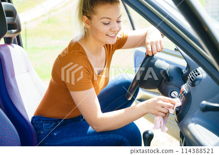 Woman cleaning car interior with cloth Woman cleaning car interior with cloth 114388521