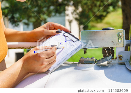 Woman checking level of propane gas in tank 114388609
