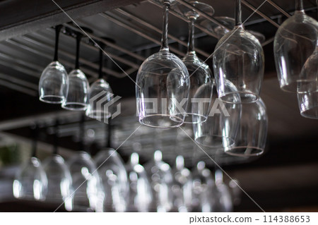 Stemware hanging from ceiling rack for elegant display in bar 114388653