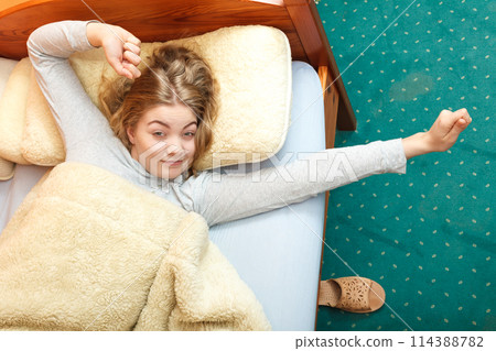 Woman stretching in bed in morning after sleeping Woman stretching in bed in morning after sleeping 114388782