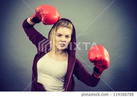 Angry woman wearing boxing gloves Angry woman wearing boxing gloves 114388786