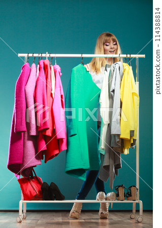 Woman choosing clothes to wear in mall or wardrobe 114388814