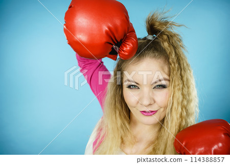 Funny girl in red gloves playing sports boxing 114388857