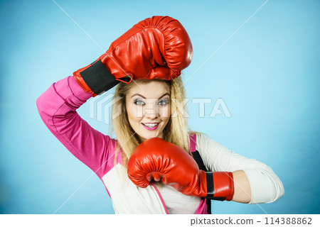 Funny girl in red gloves playing sports boxing Funny girl in red gloves playing sports boxing 114388862