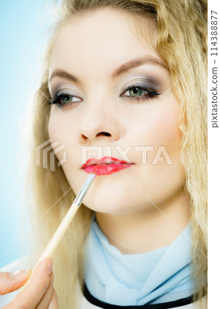 Applying lipstick on fashion model lips 114388877