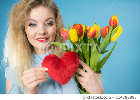 Woman holds tulips and red heart Woman holds tulips and red heart 114388985
