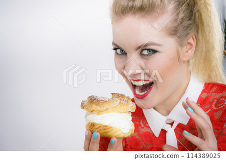 Woman holding cupcake dessert with cream Woman holding cupcake dessert with cream 114389025