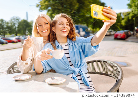 Beautiful woman friends using smartphone selfie together. Fashion, beauty, blogging, tourism. Beautiful woman friends using smartphone selfie together. Fashion, beauty, blogging, tourism. 114389074