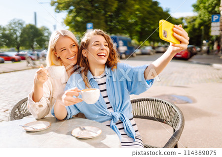 Beautiful woman friends using smartphone selfie together. Fashion, beauty, blogging, tourism. Beautiful woman friends using smartphone selfie together. Fashion, beauty, blogging, tourism. 114389075